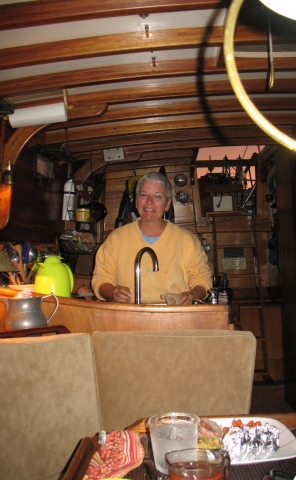 Pat serving up Thanksgiving dinner aboard (anchored out in the middle of the Bahama Banks..No land in sight).